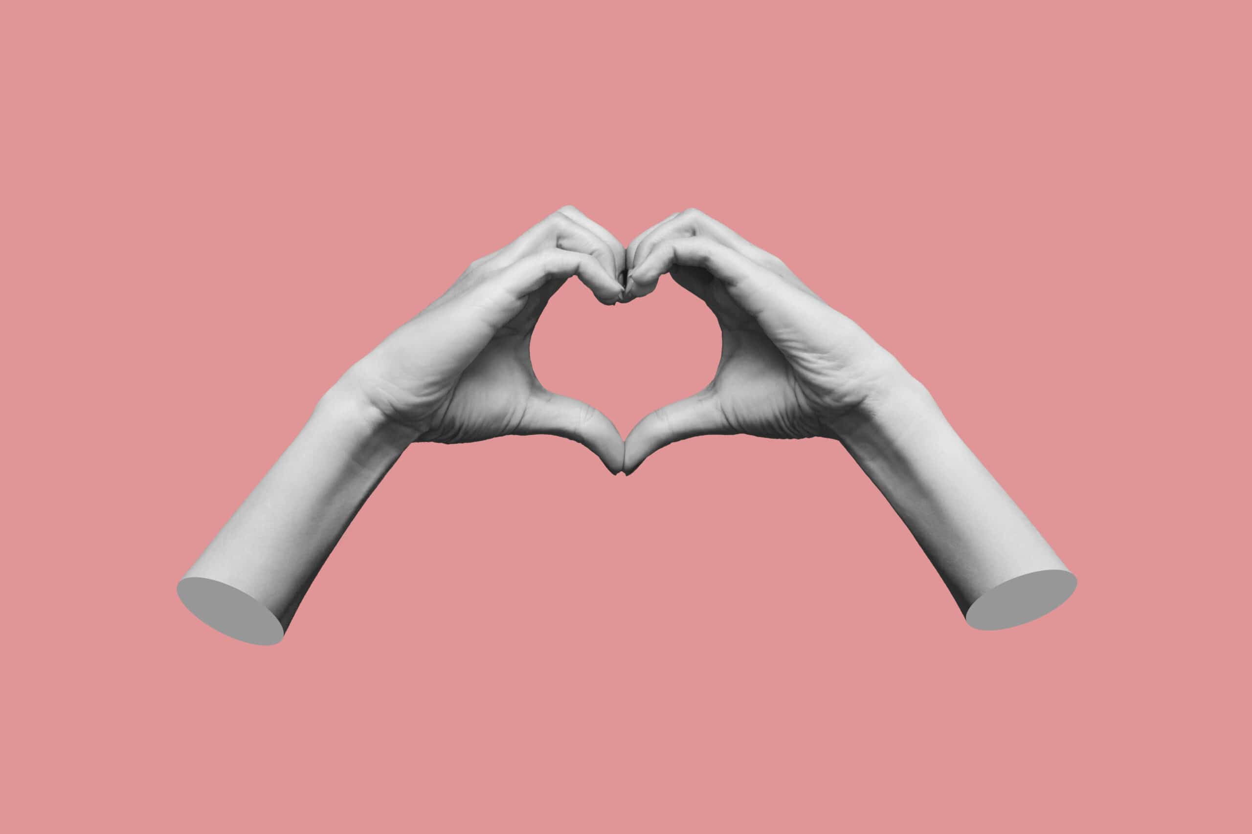 Human female hands showing a heart shape isolated on a pink colo